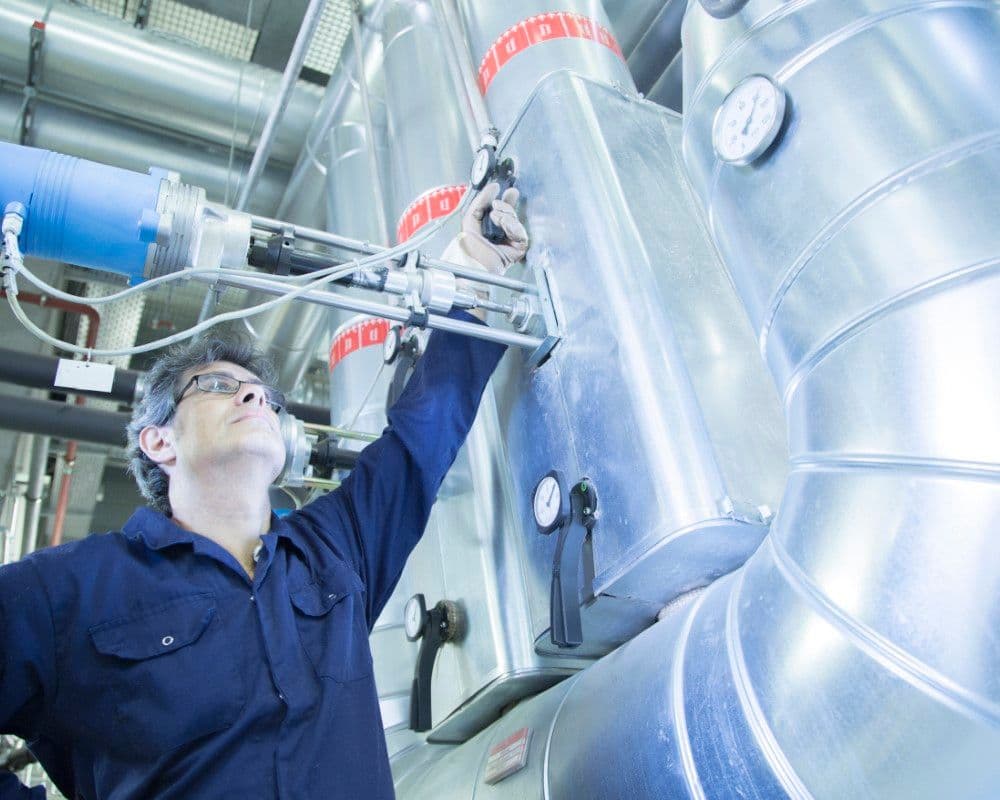 tecnico revisando sistemas de calor para evitar fugas en proceso de ahorro energético industrial.jpg